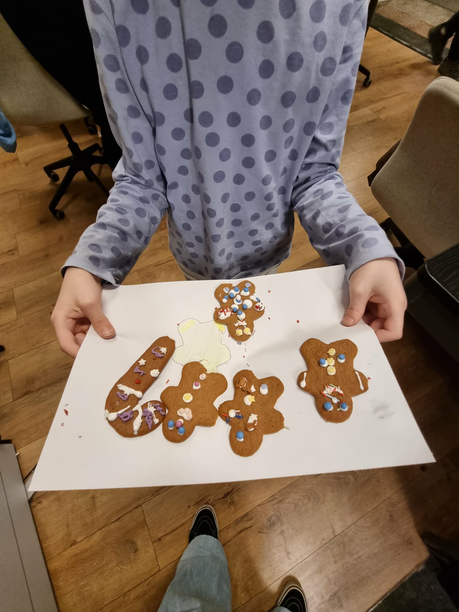 Dziewczynka trzyma kilka ozdobionych pierniczków.