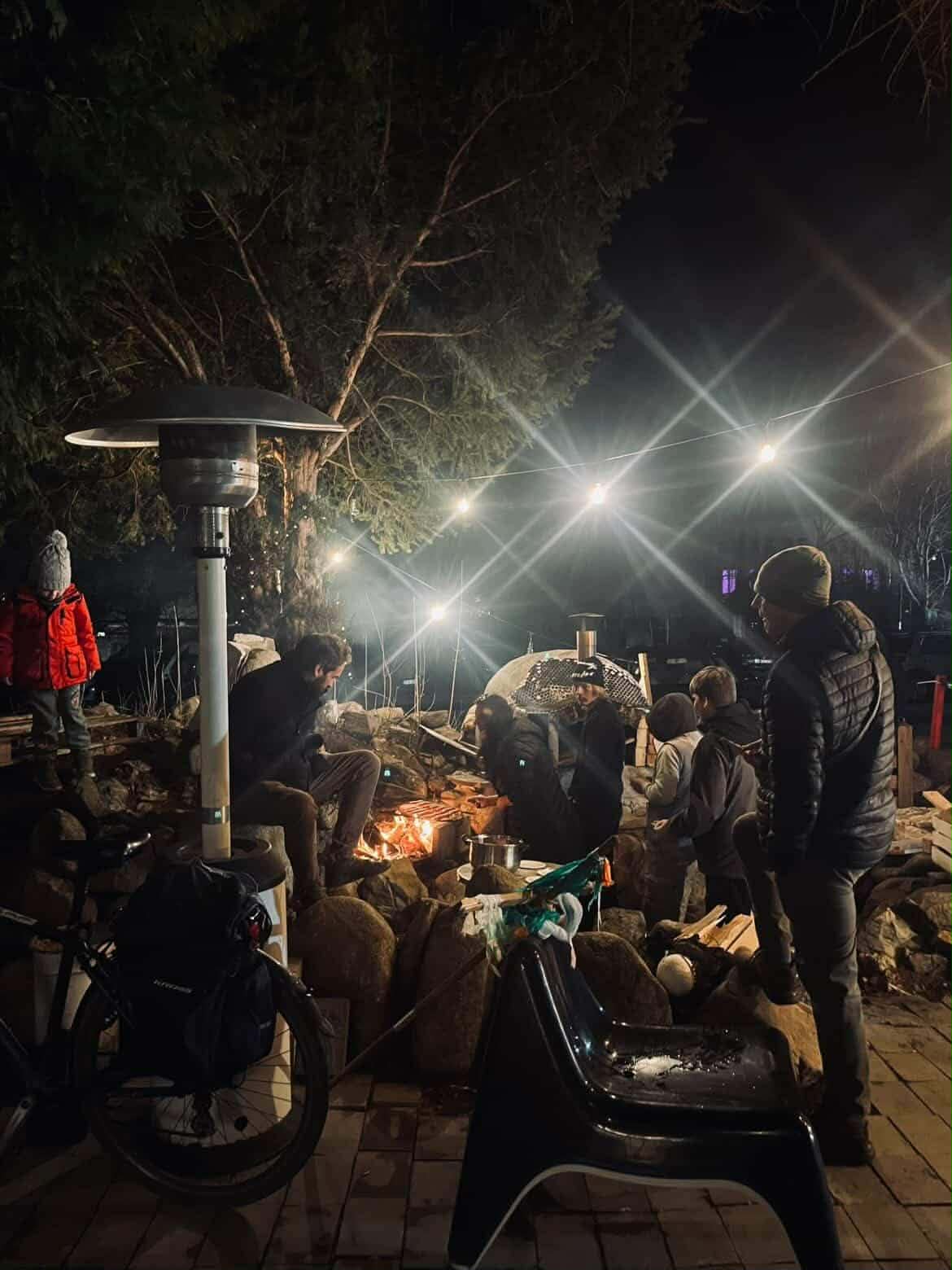 Młodzież rozpala ognisko.