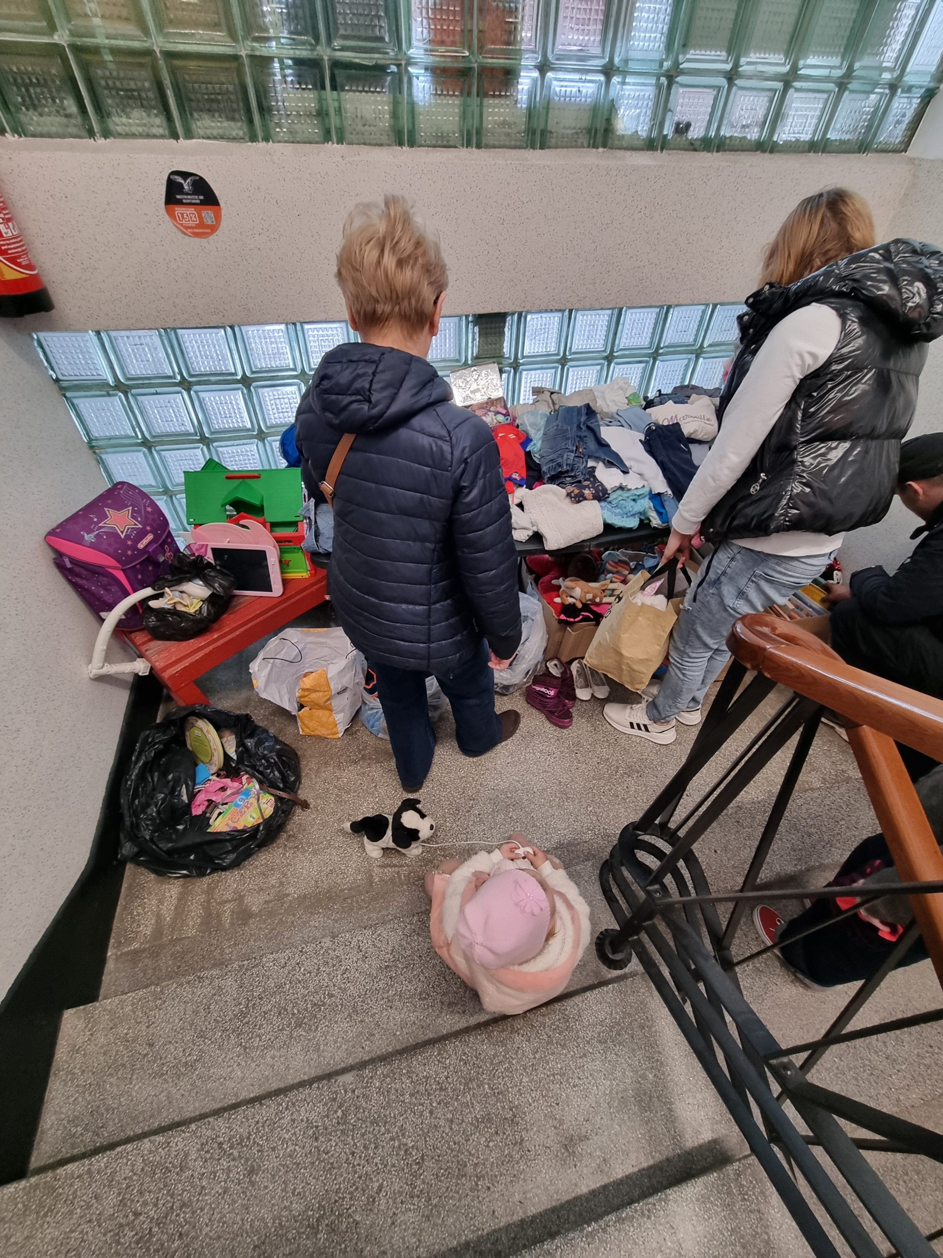 dwie kobiety i dziecko oglądają zabawki