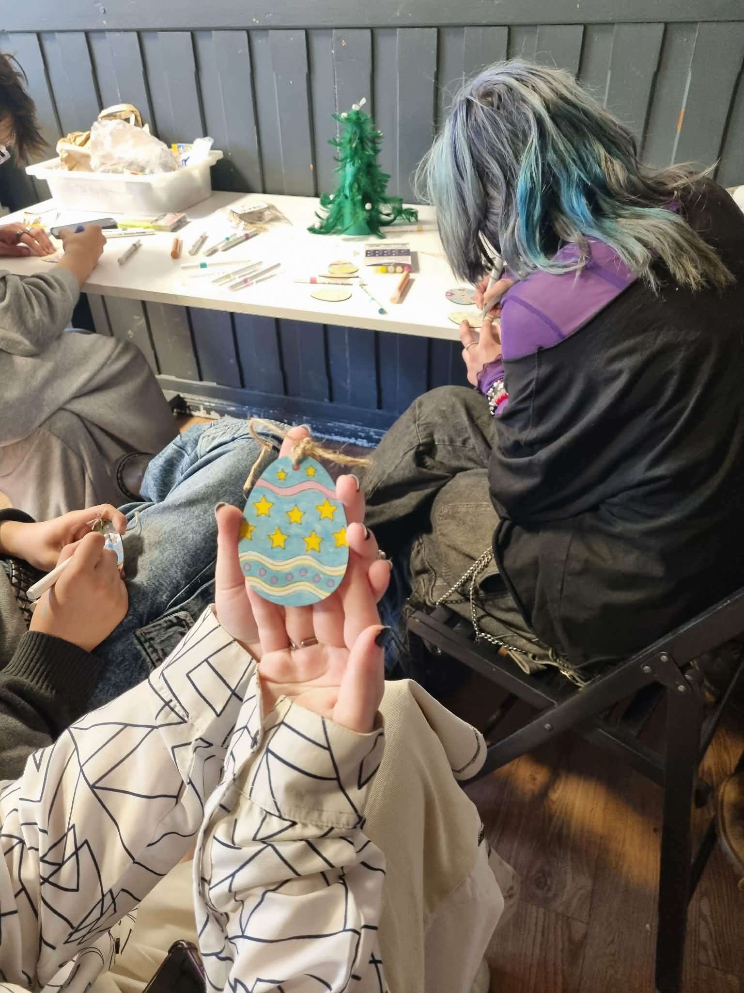 Dziewczyna trzyma w dłoniach pomalowaną pisankę.