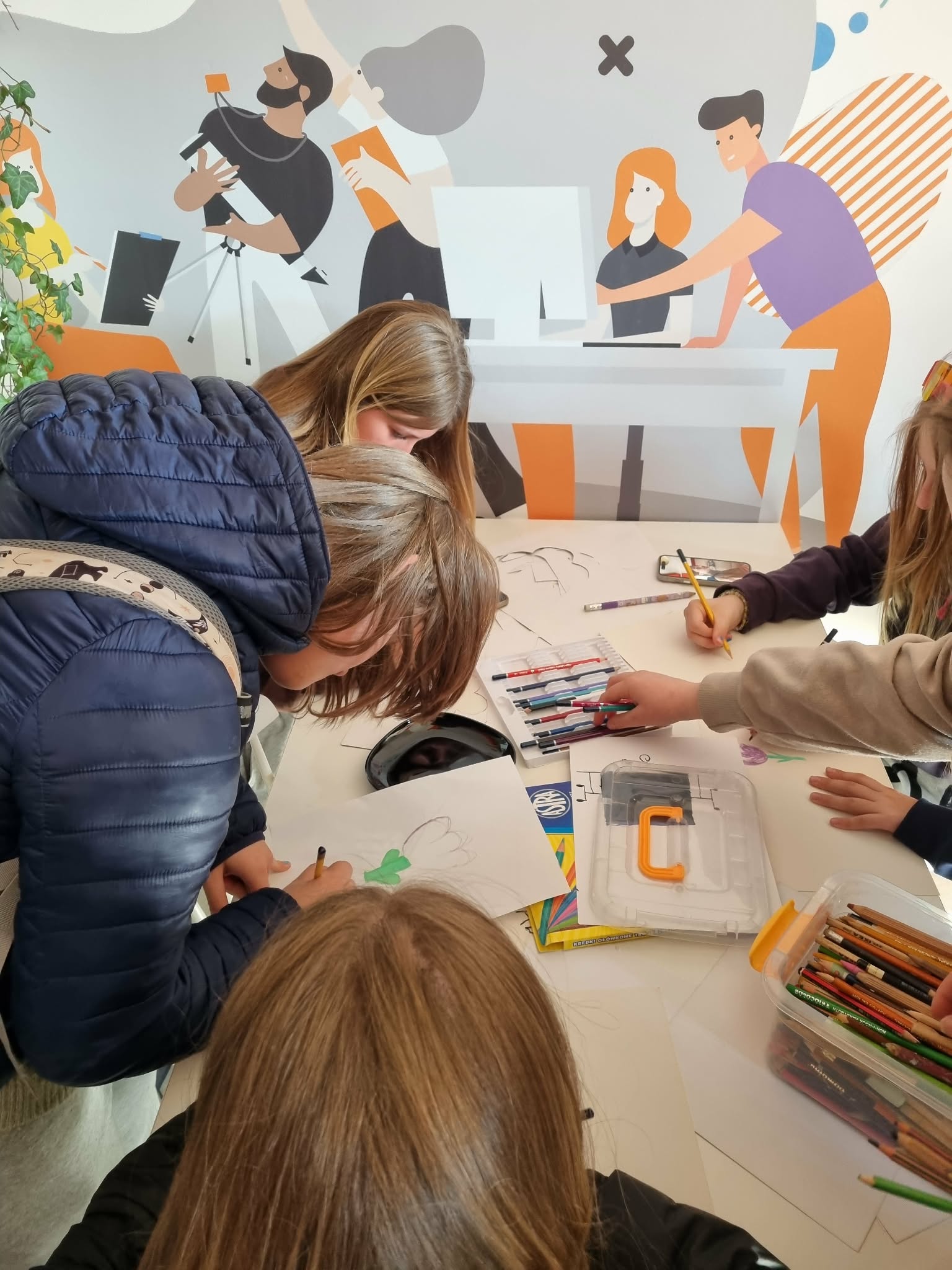 Kilka dziewczyn rysuje przy stole