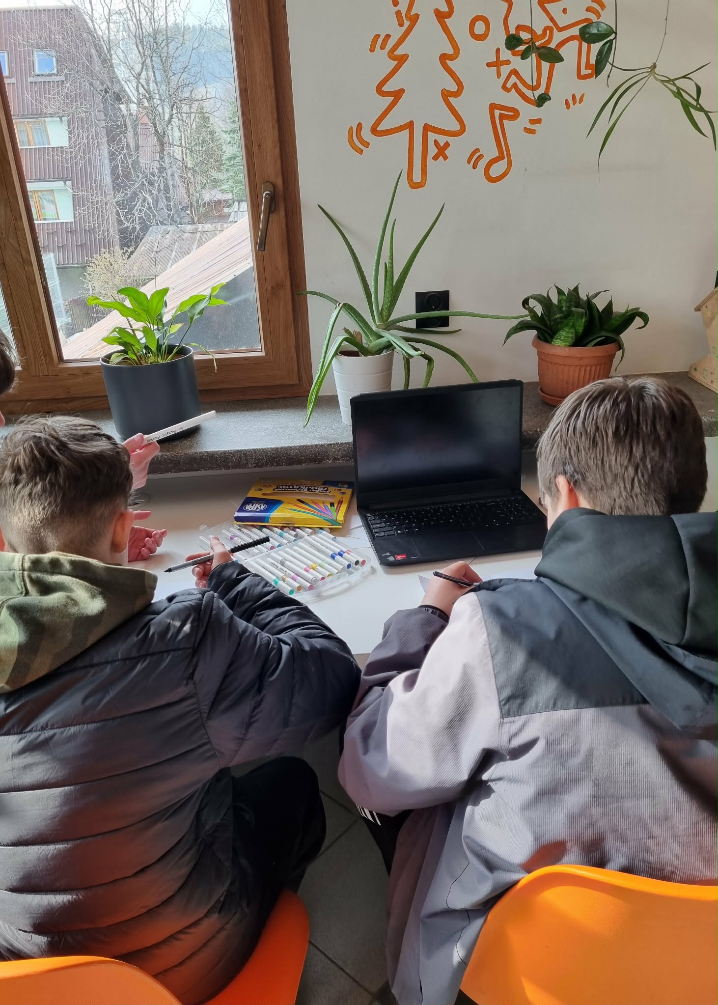 Dwóch chłopców odrysowuje laptopa