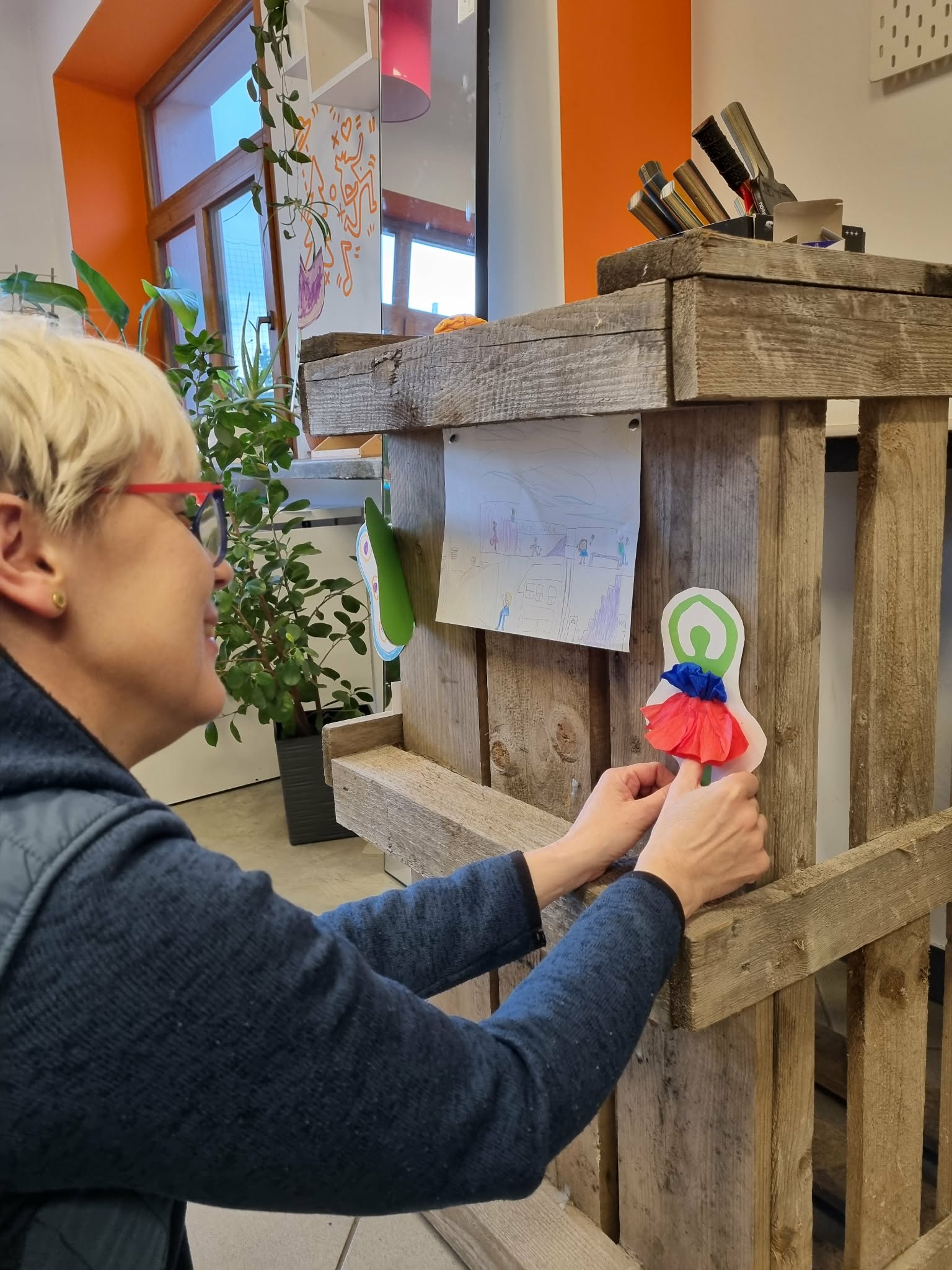 Kobieta przyczepia do skrzyni postać tancerki