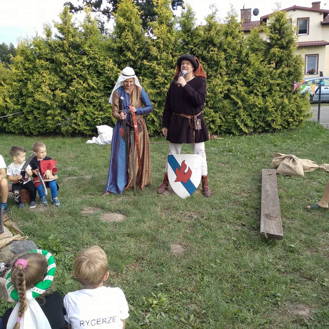Na zdjęciu znajduje się kobieta i mężczyzna w przebraniach przypominających średniowieczne stroje.