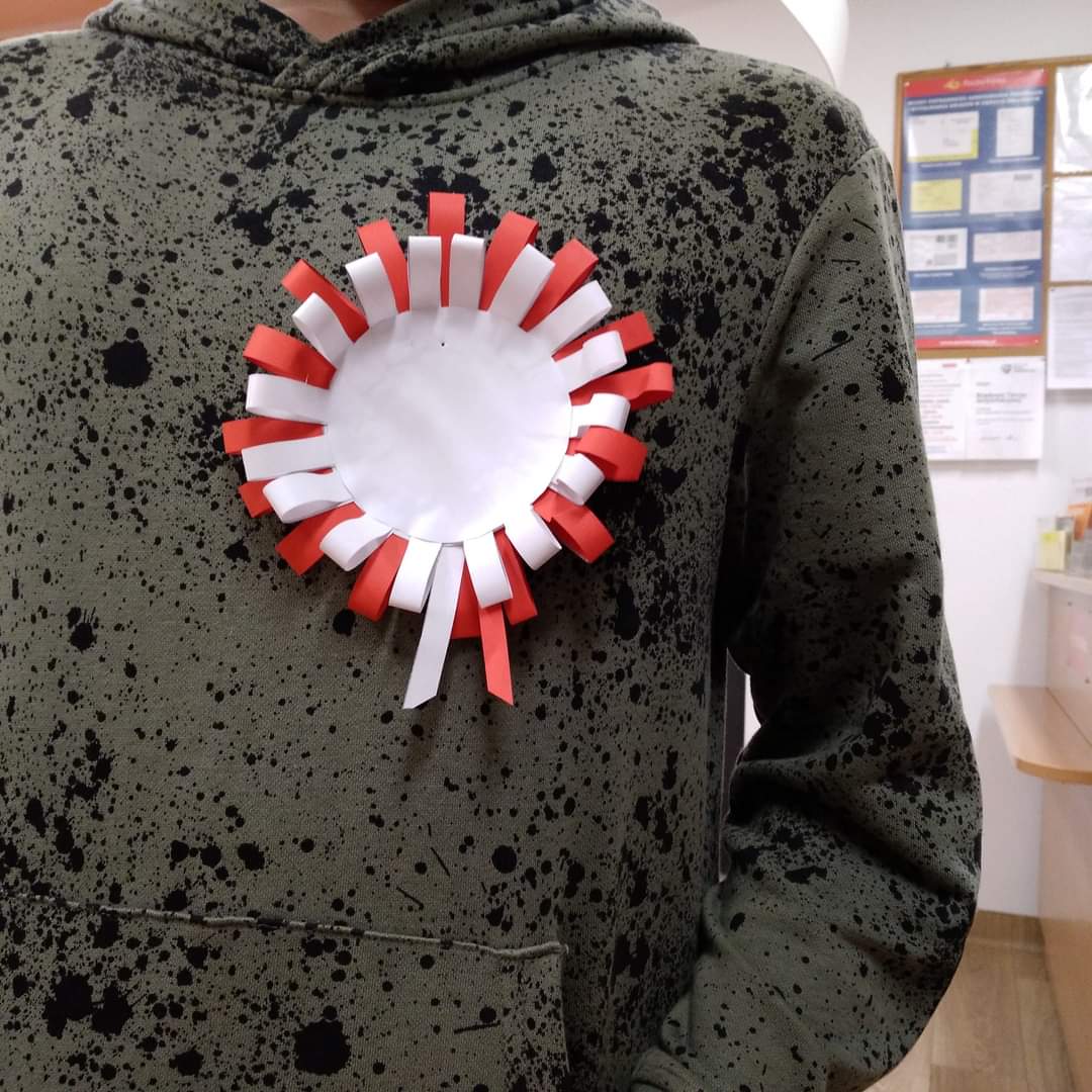 Kotylion w kolorze białym i czerwonym.