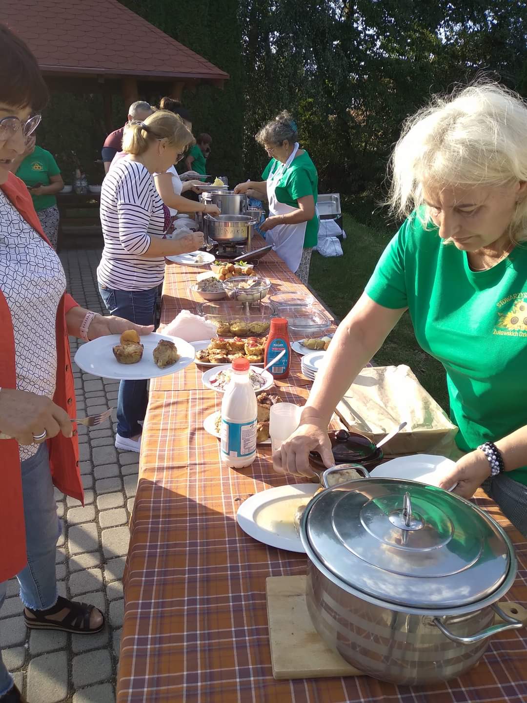 Kobiety nakładają jedzenie na talerze.