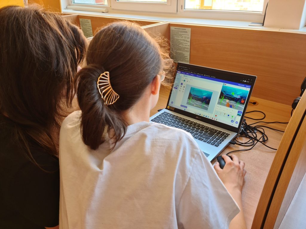 2 dziewczęta wykonują zadanie z programowania na laptopie