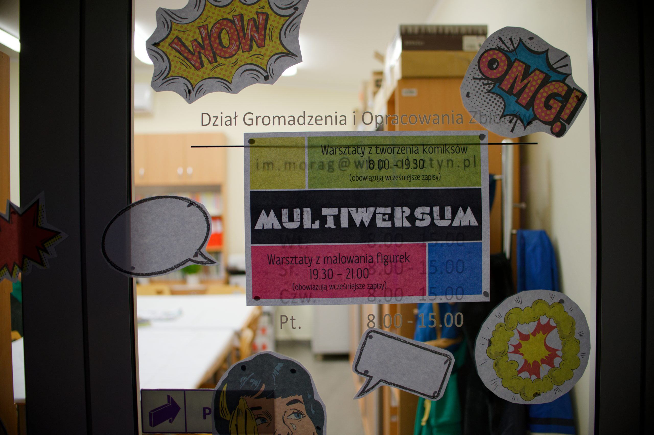 Plakat informujący o warsztatach i dekoracje w tematyce komiksu powieszone na drzwiach.