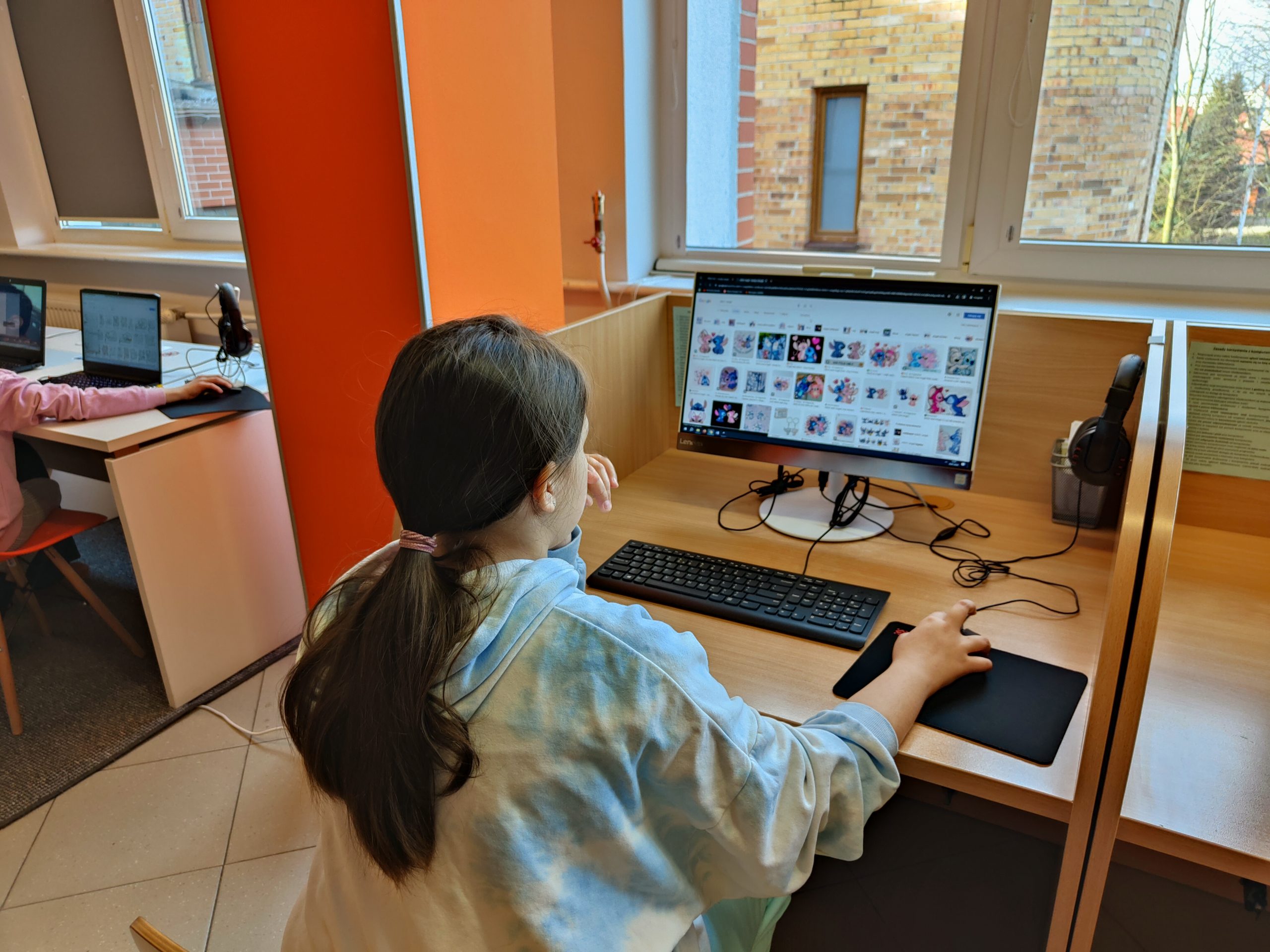 Dziewczynka korzystająca z komputera.