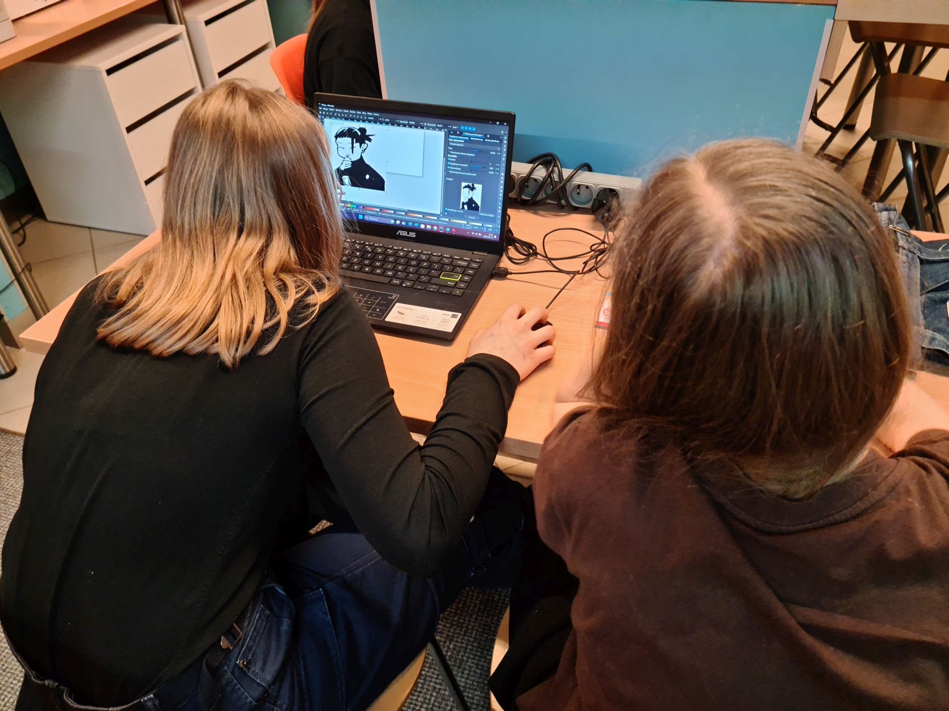 dwie dziewczyny siedzą przy komputerze