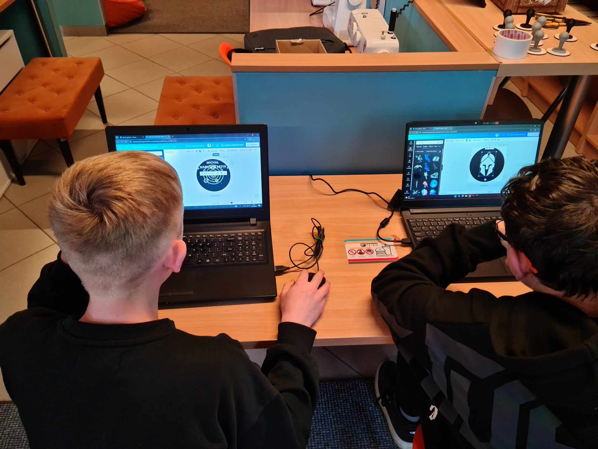 dwóch chłopaków siedzi przy laptopach