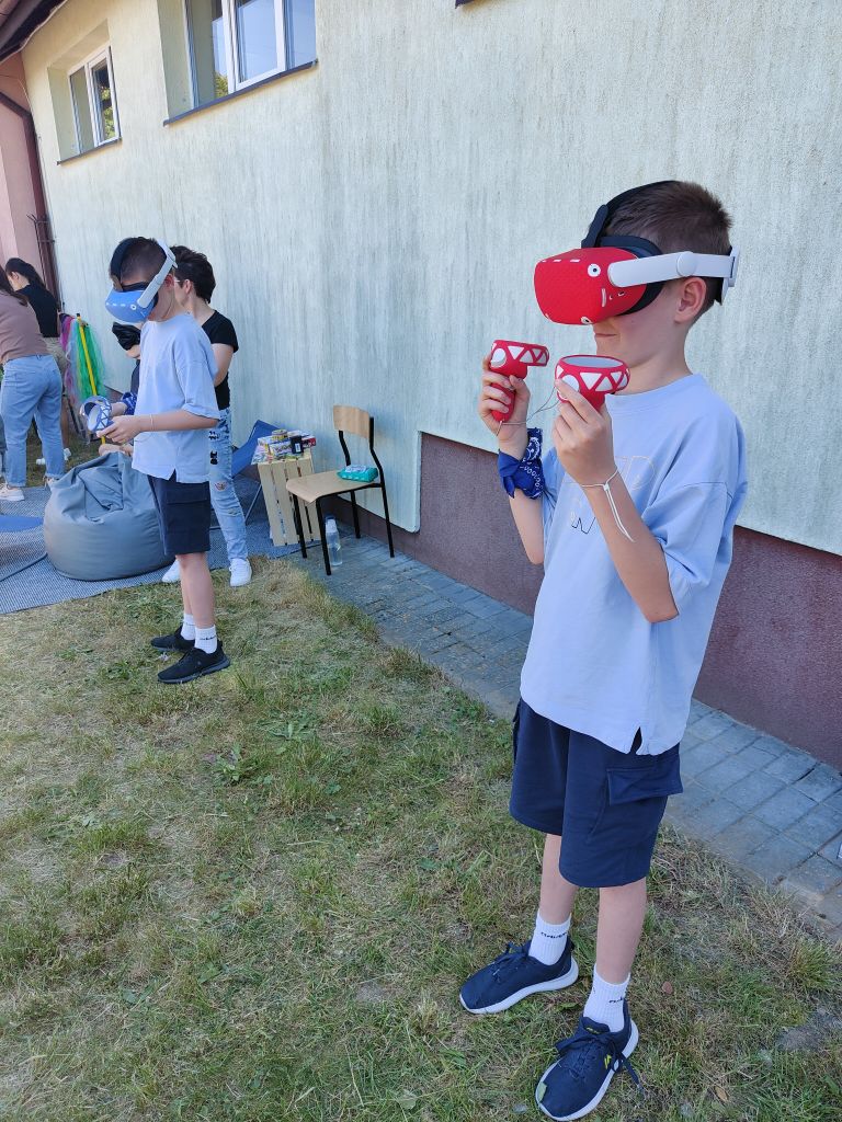 dwóch chłopców korzysta z gogli wirtualnej rzeczywistości na dworze