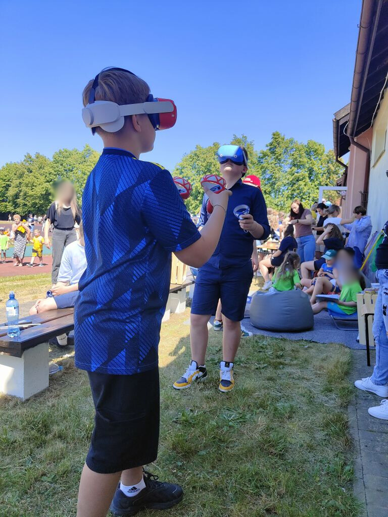 dwóch chłopców korzysta z gogli wirtualnej rzeczywistości na dworze