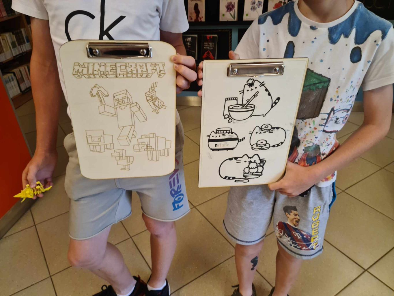 dwóch chłopców prezentuje clipboardy