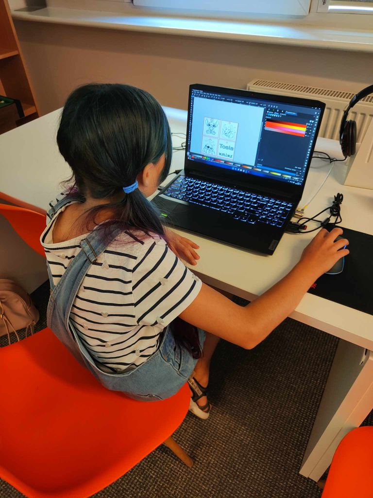 dziewczynka siedzi przy laptopie