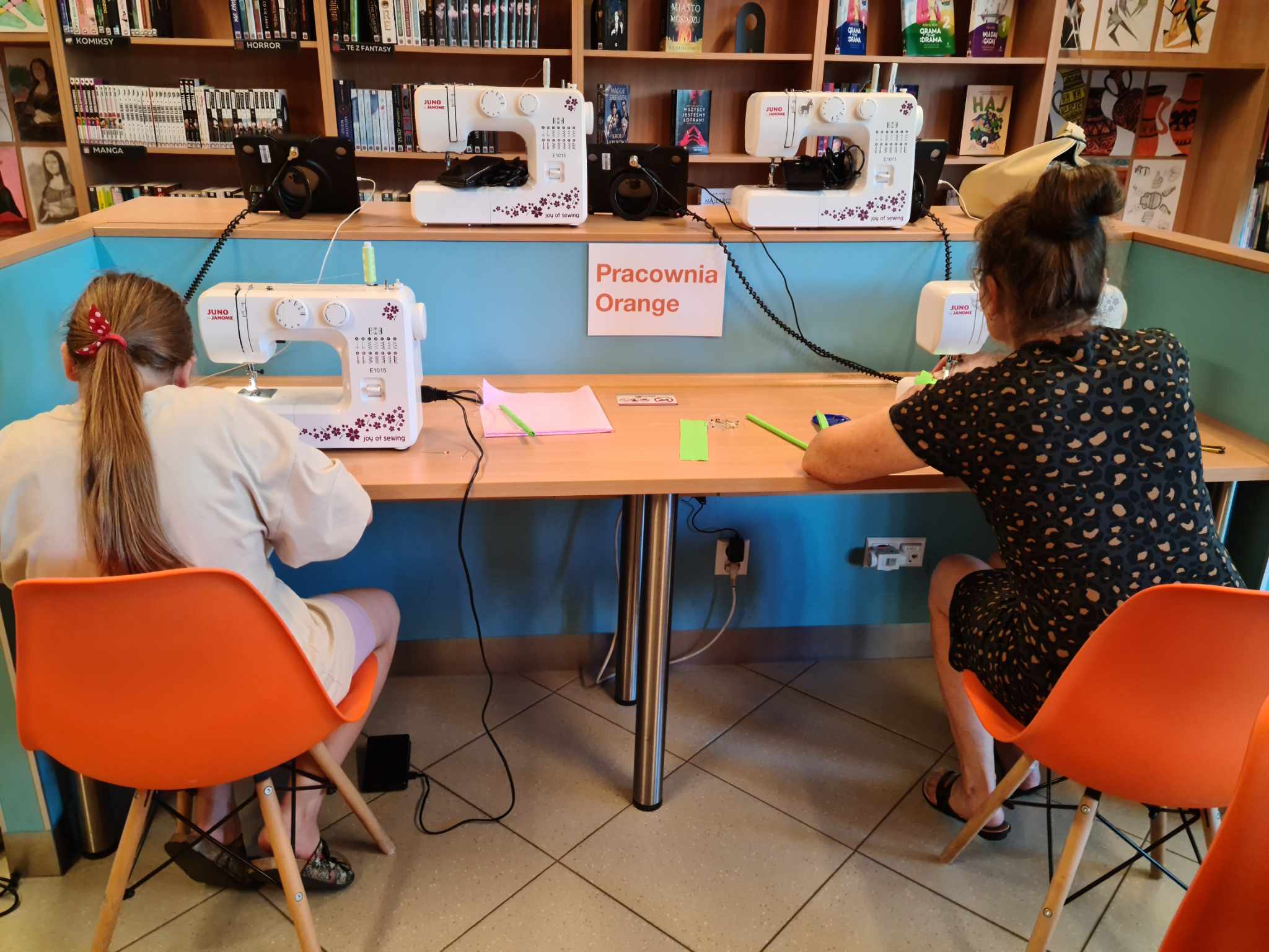 dziewczyna i kobieta siedzą przy maszynach do szycia