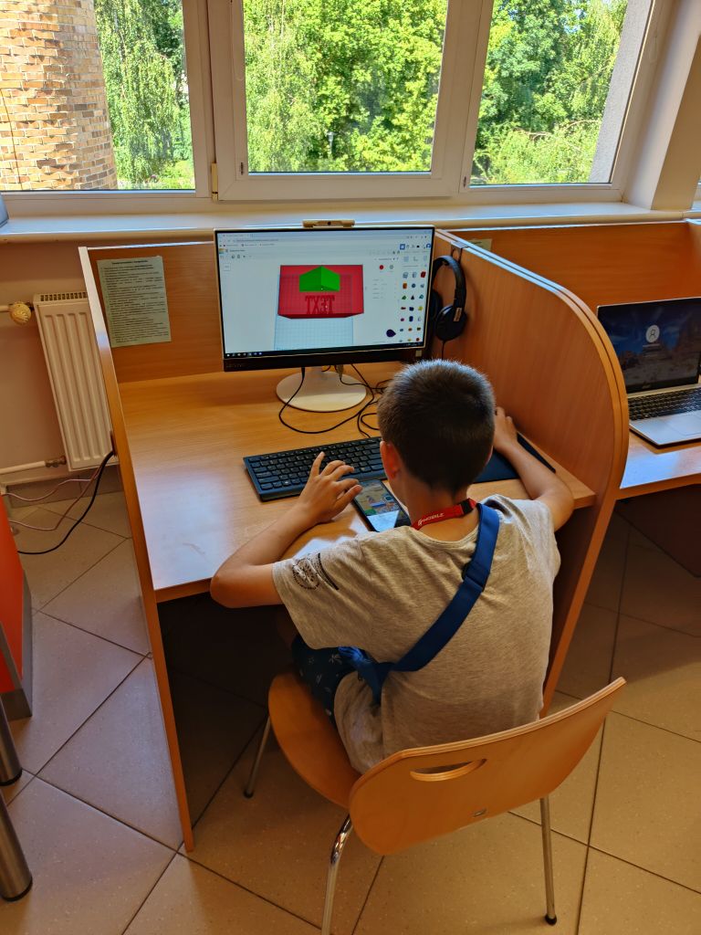 Chłopiec siedzi przy komputerze