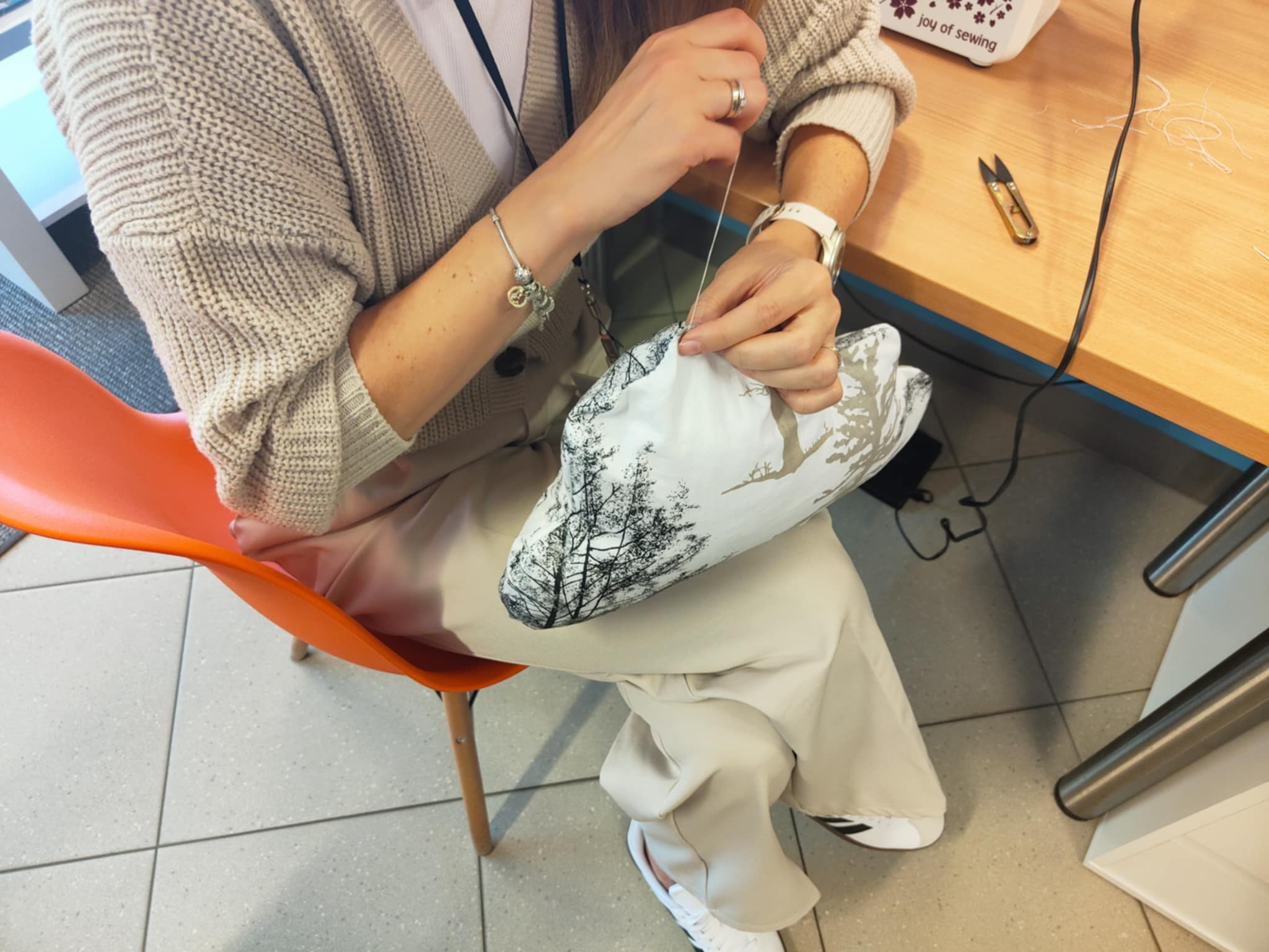 Ujęcie na kobiece ręce szyjące igłą