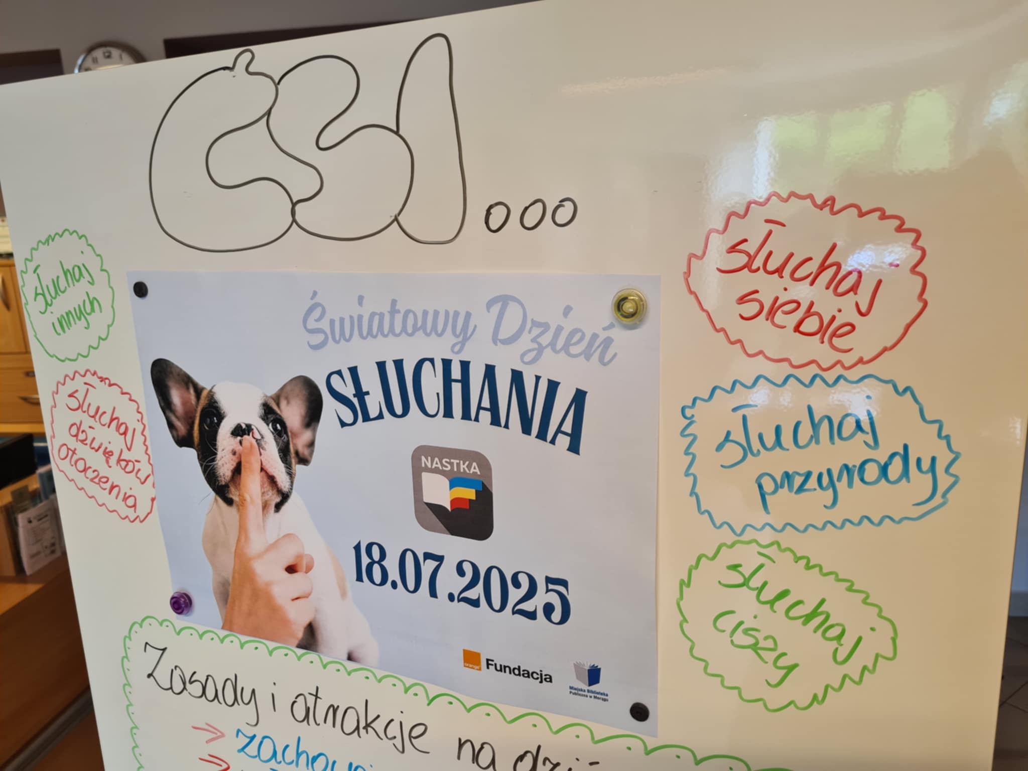 Tablica z plakatem Światowego Dnia Słuchania i kolorowymi hasłami zachęcającymi do wsłuchiwania się w ciszę, siebie i innych.