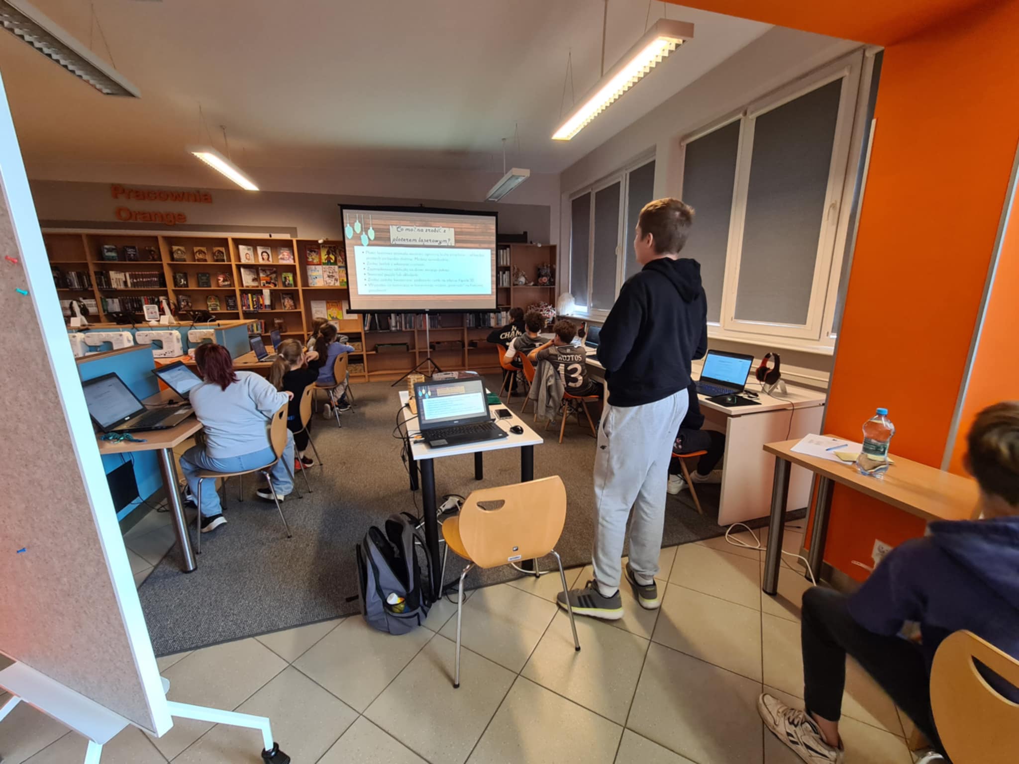 Uczestnicy warsztatów słuchają prelekcji o projektowaniu graficznym w Pracowni Orange.