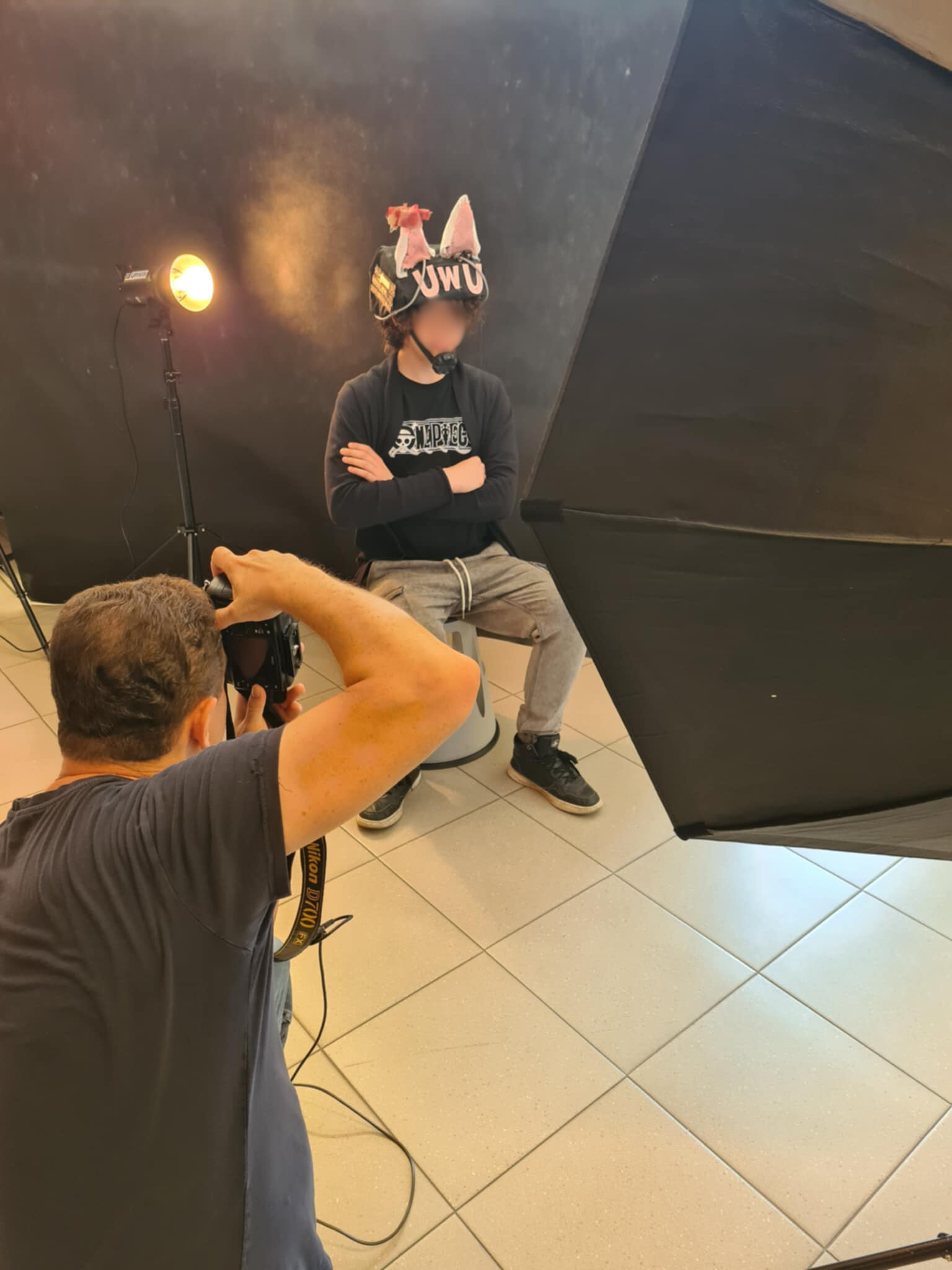 Fotografuje chłopca w dekoracyjnym kapeluszu w studiu zdjęciowym.