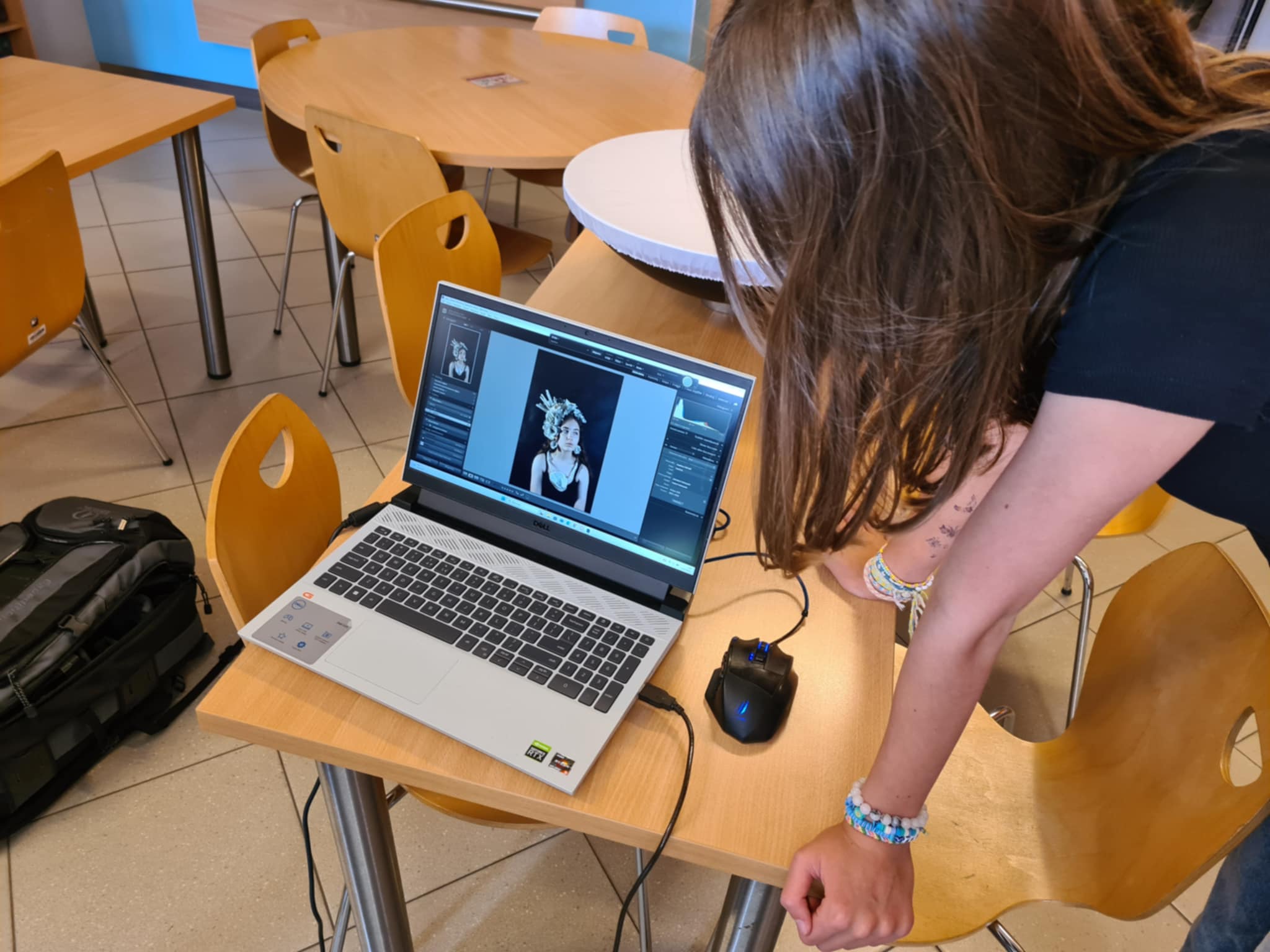 Dziewczyna ogląda portret na ekranie laptopa podczas warsztatów fotograficznych.