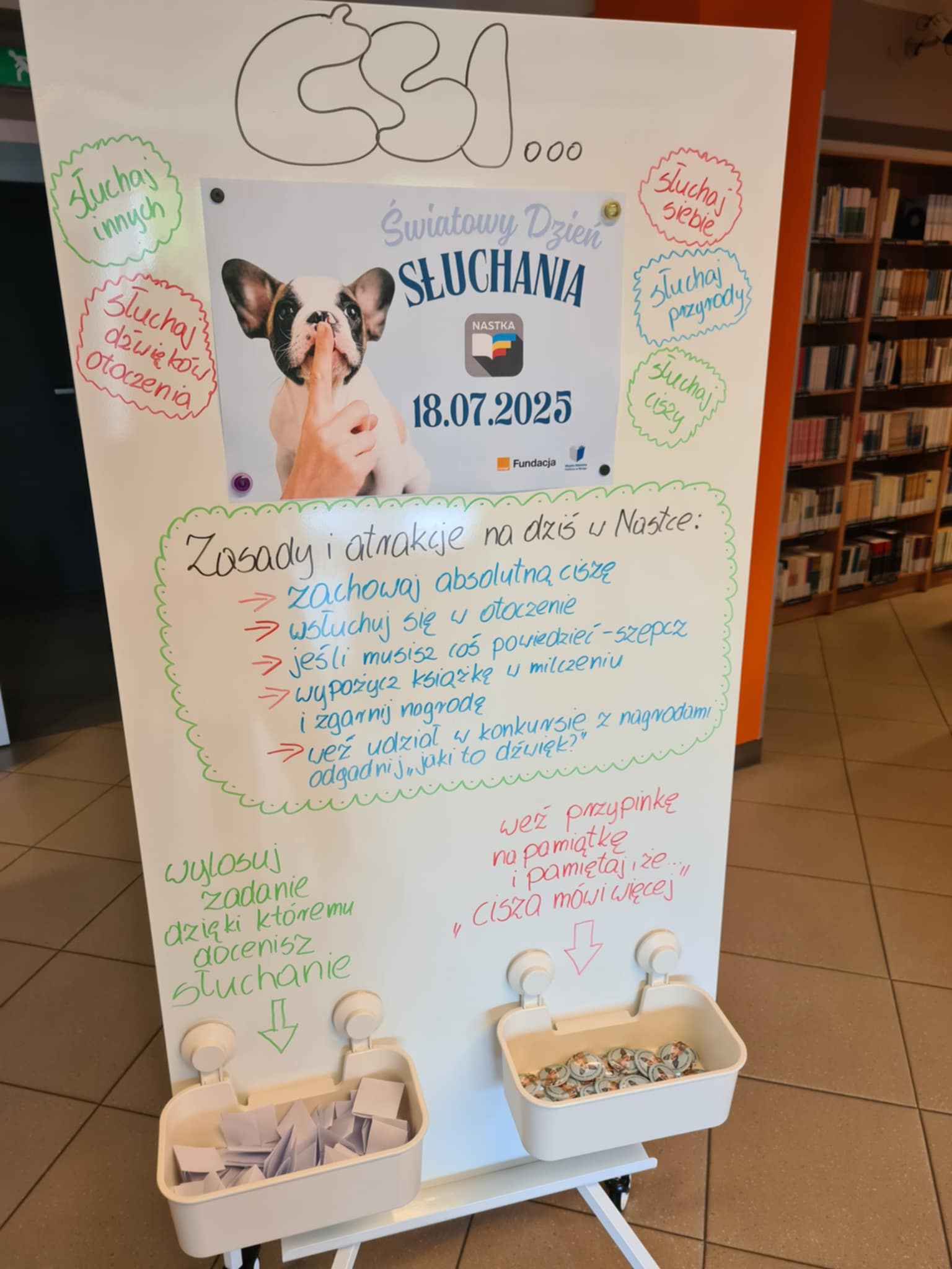 Cała plansza informacyjna z zasadami, zadaniami do losowania i przypinkami przygotowana na Dzień Słuchania.