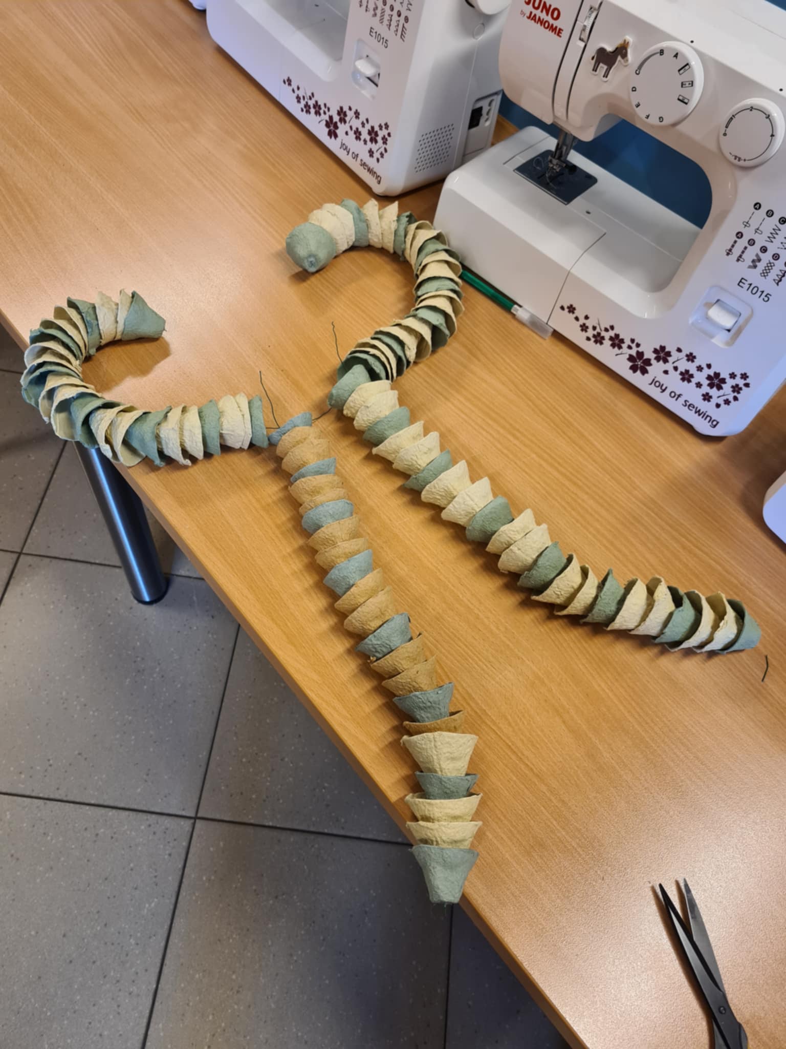 Dwa gotowe elementy wykonane z pociętych wytłoczek po jajkach, ułożone na stole.