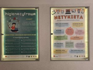 Dwie podświetlane gabloty obok siebie: po lewej plakat o higienie cyfrowej, po prawej plakat o zasadach netykiety.