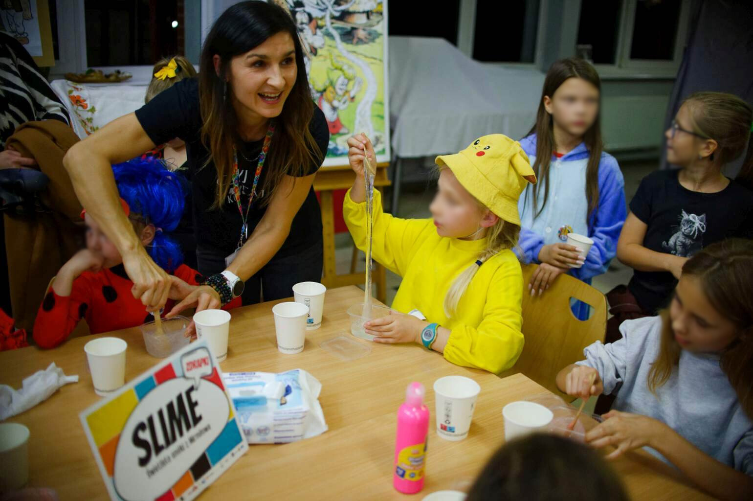 Dzieci robią slime’a podczas warsztatów kreatywnych z animatorką.
