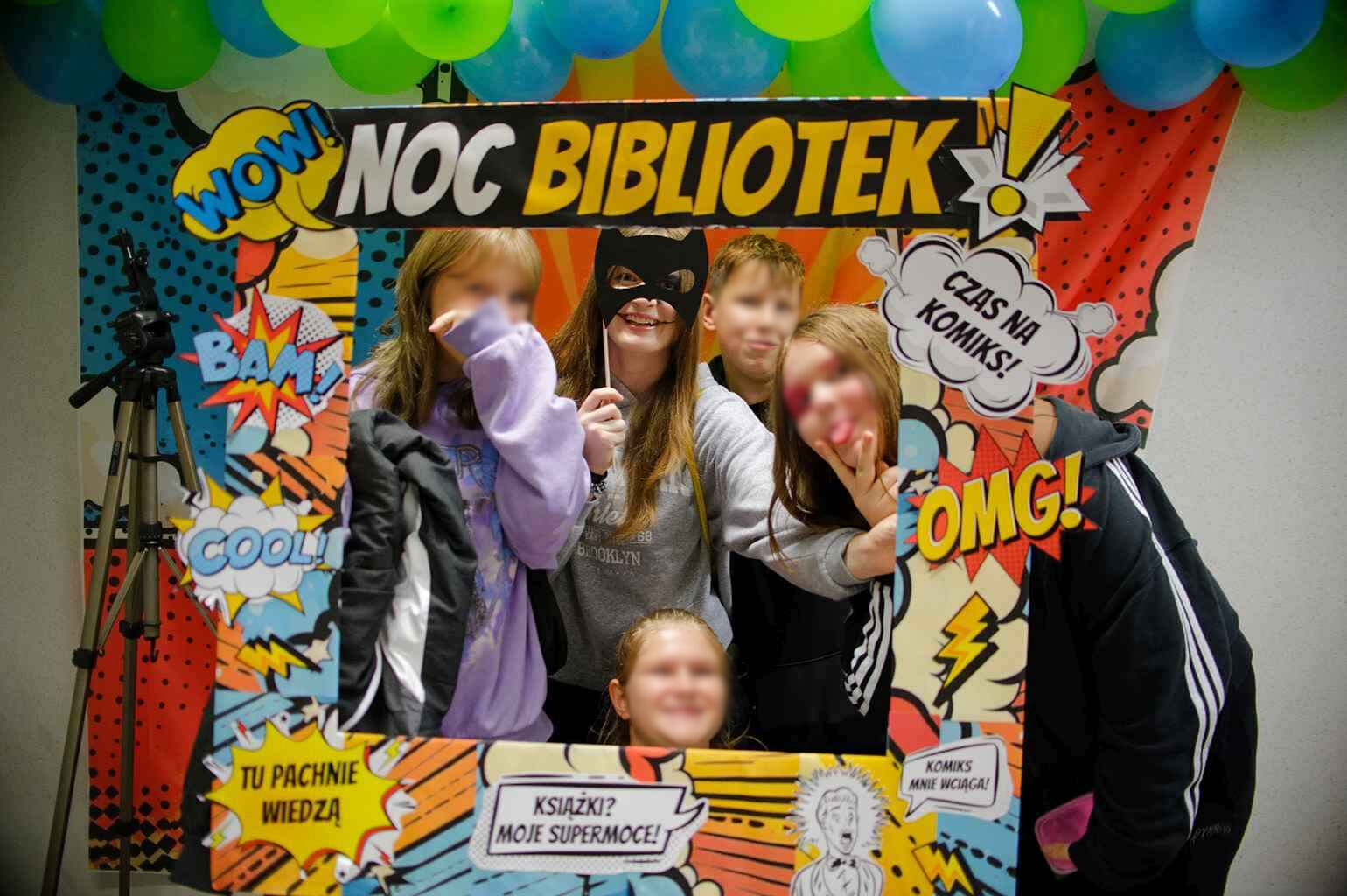 Grupa młodzieży pozuje do zdjęcia w komiksowej ramce „Noc Bibliotek”.