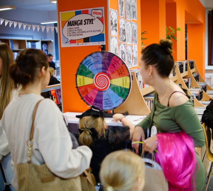Zdjęcie z biblioteki – przy stanowisku z kołem fortuny „Manga Styl” uczestnicy wydarzenia biorą udział w zabawie inspirowanej mangą.
