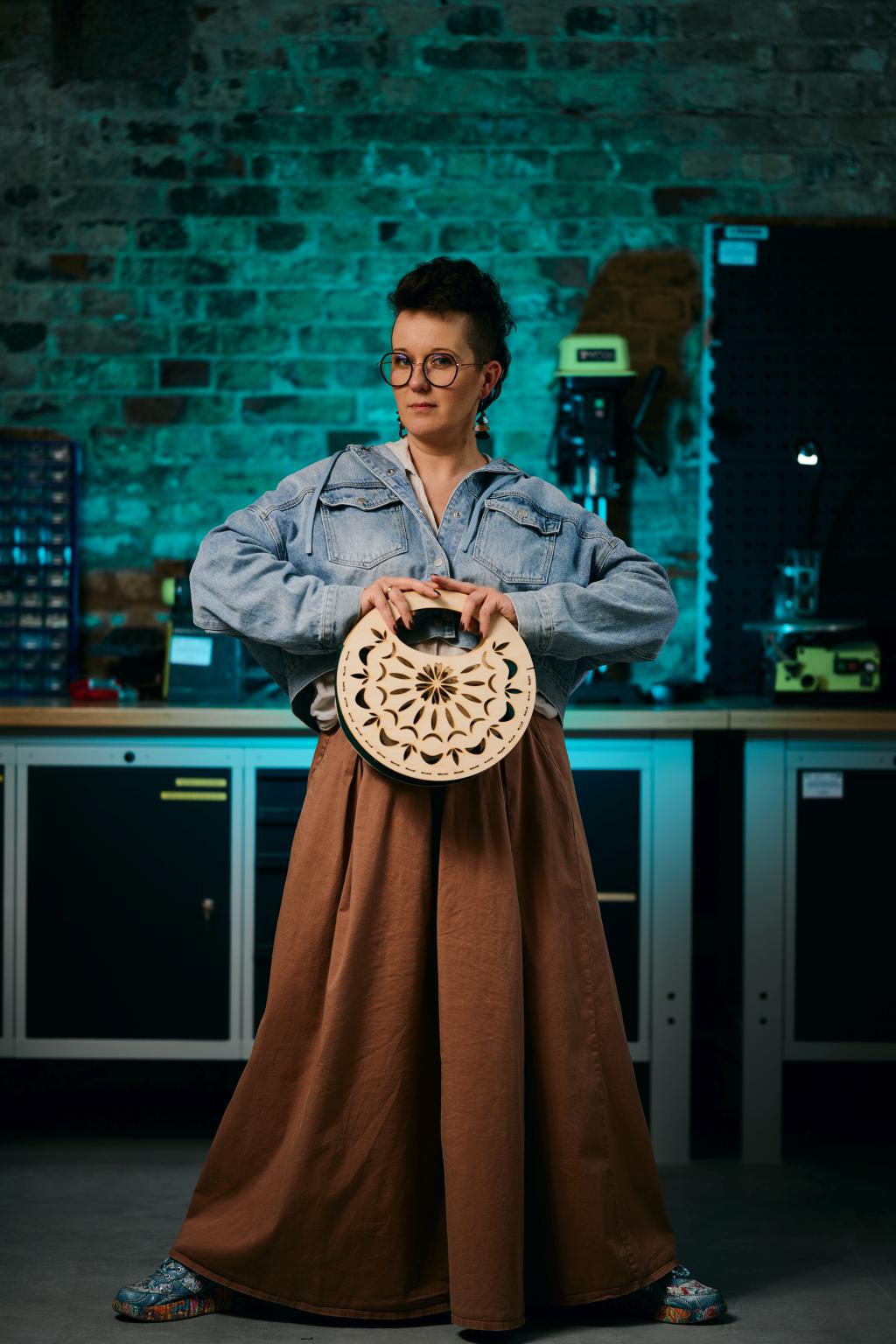 Osoba z drewniana torebką w pracowni oświetlonej niebieskim światłem.