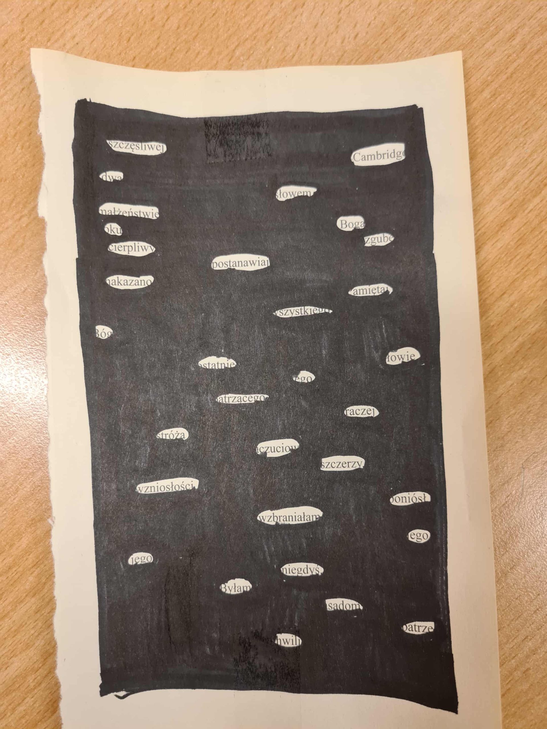 Strona książki zamalowana na czarno, z pozostawionymi słowami tworzącymi krótki poetycki tekst.