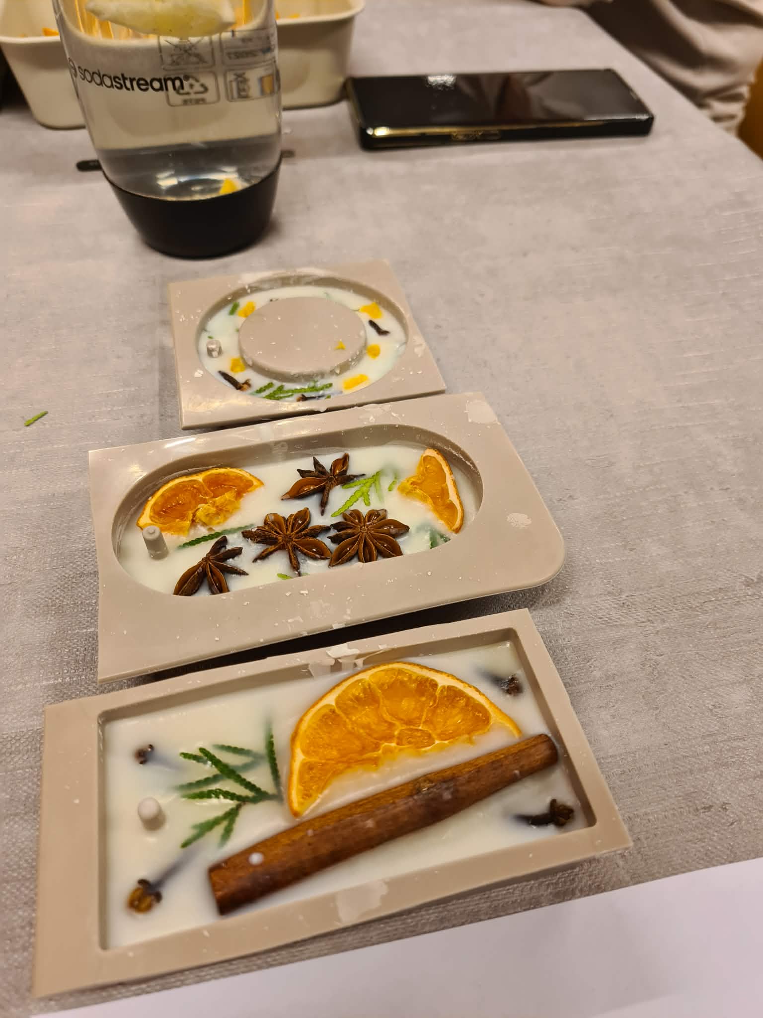 Formy z woskiem i przyprawami na stole warsztatowym.