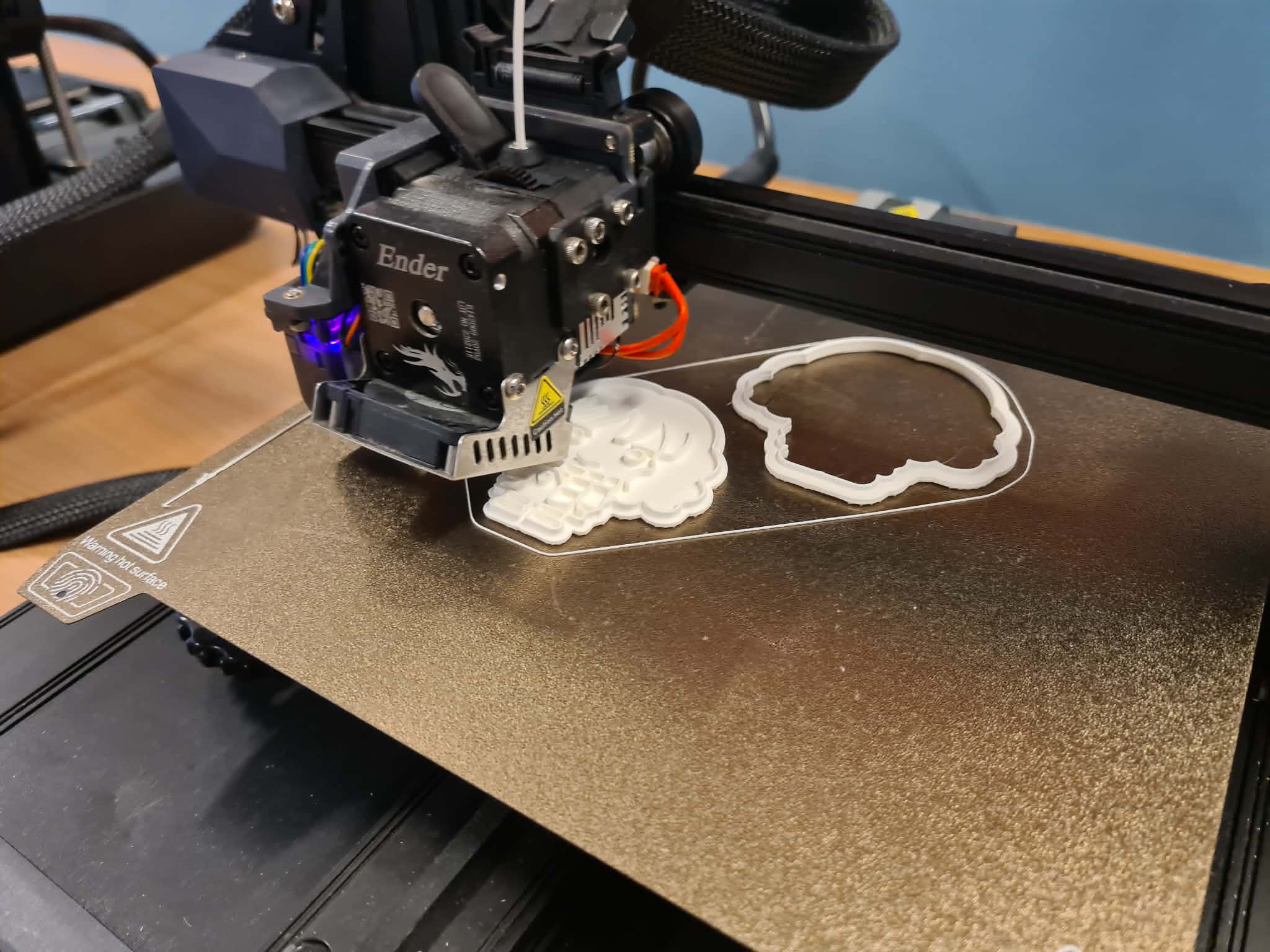 Drukarka 3D Ender podczas drukowania foremki w kształcie postaci.