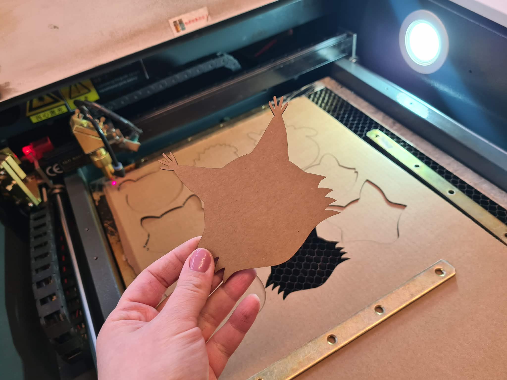 Wycinanie kartonowego kształtu zwierzątka na ploterze laserowym.