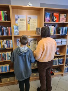 Chłopiec i dziewczynka czytają plansze o niedźwiedziu polarnym.