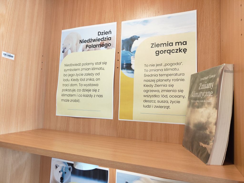 Plansze „Dzień Niedźwiedzia Polarnego” na tle drewnianego regału.