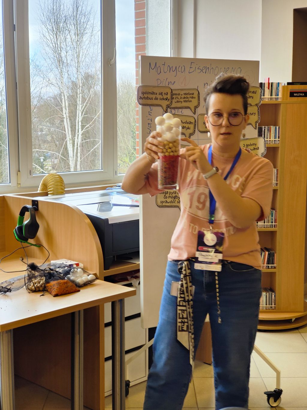 Prowadząca warsztaty pokazuje słoik z elementami podczas zajęć o zarządzaniu czasem.