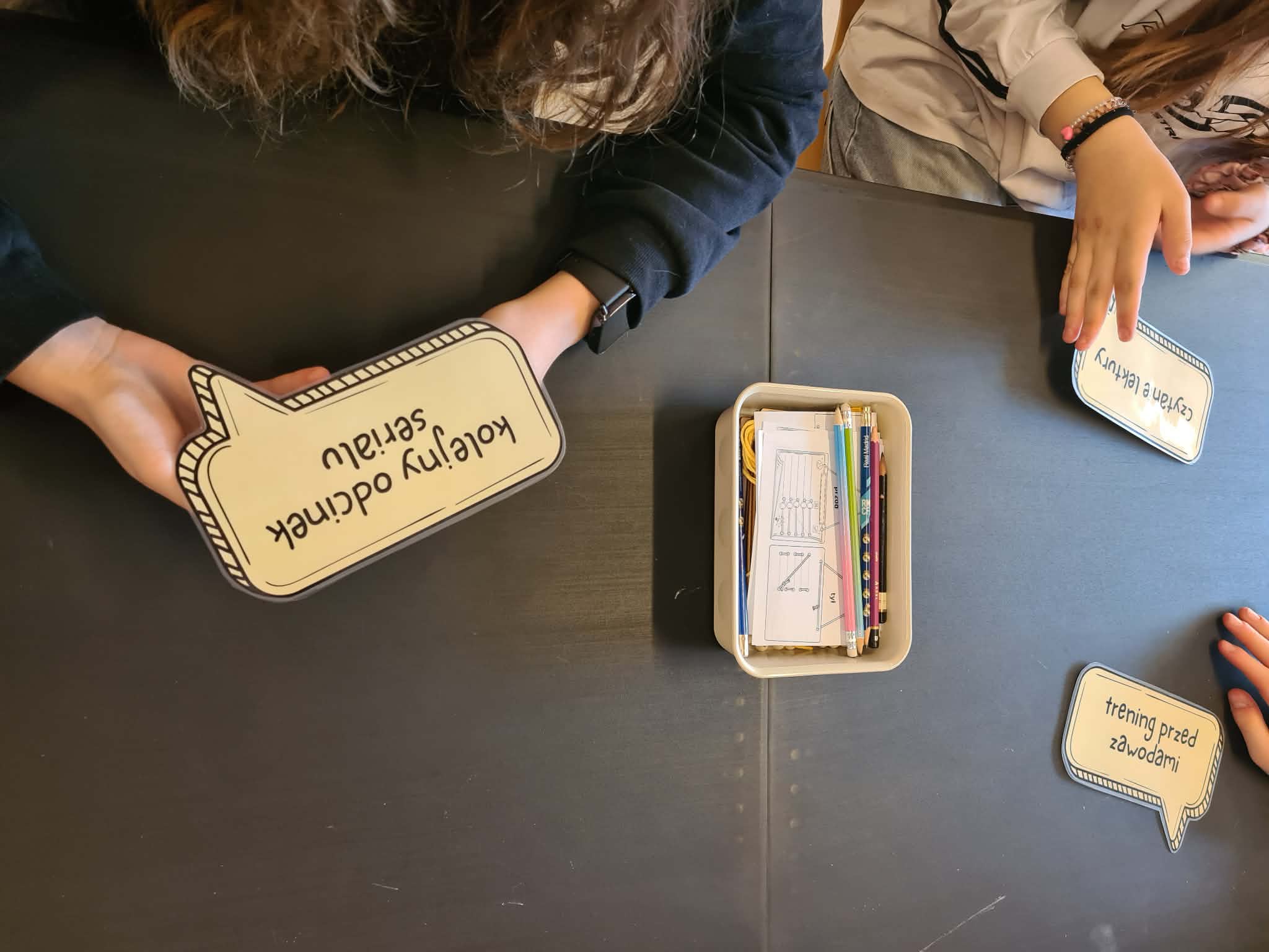 Uczestniczki zajęć układają na stole karty z przykładami zadań według matrycy Eisenhowera.