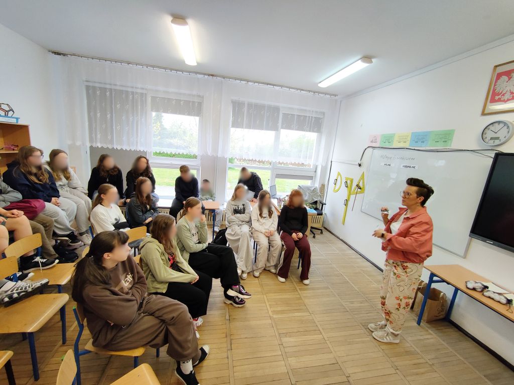 Grupa uczniów uczestniczy w zajęciach o organizacji czasu. Bibliotekarka stoi przy tablicy, na której przygotowano matrycę Eisenhowera.
