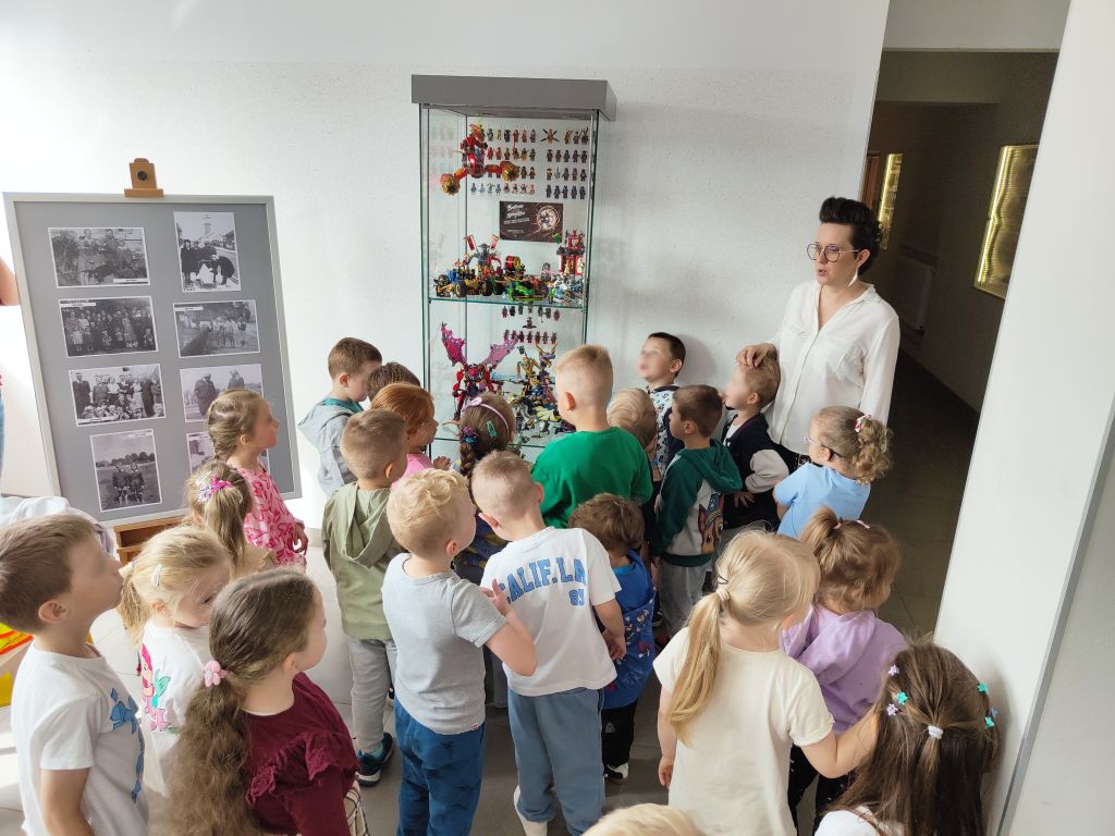 Przedszkolaki oglądają wystawę LEGO Ninjago w bibliotecznej gablocie.