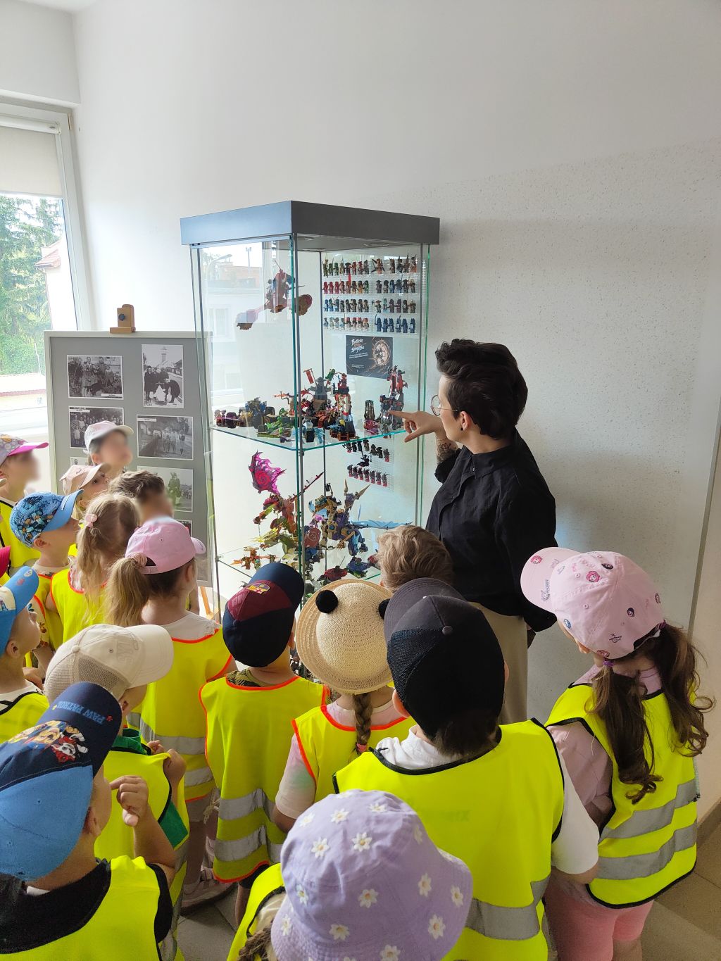 Przedszkolaki oglądają kolekcję LEGO Ninjago podczas zwiedzania biblioteki.