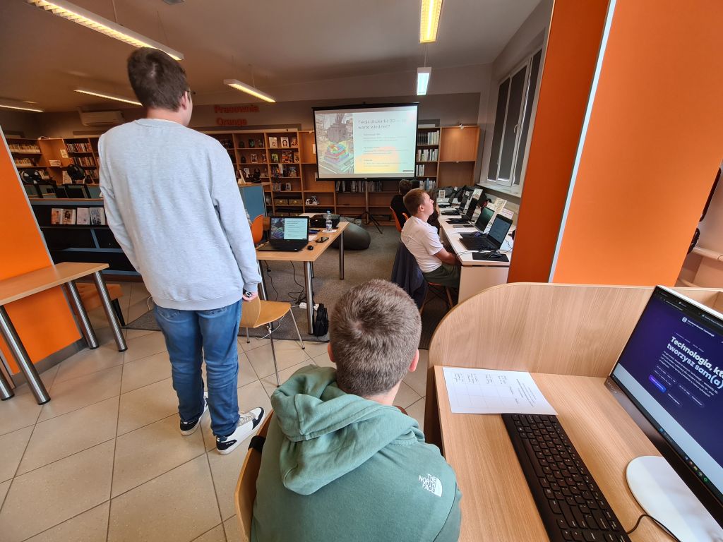 Uczestnicy pierwszego dnia Akademii Nowych Technologii – edycja II podczas warsztatów w Pracowni Orange w Morągu, pracujący przy komputerach nad projektami z wykorzystaniem sztucznej inteligencji i technologii 3D.