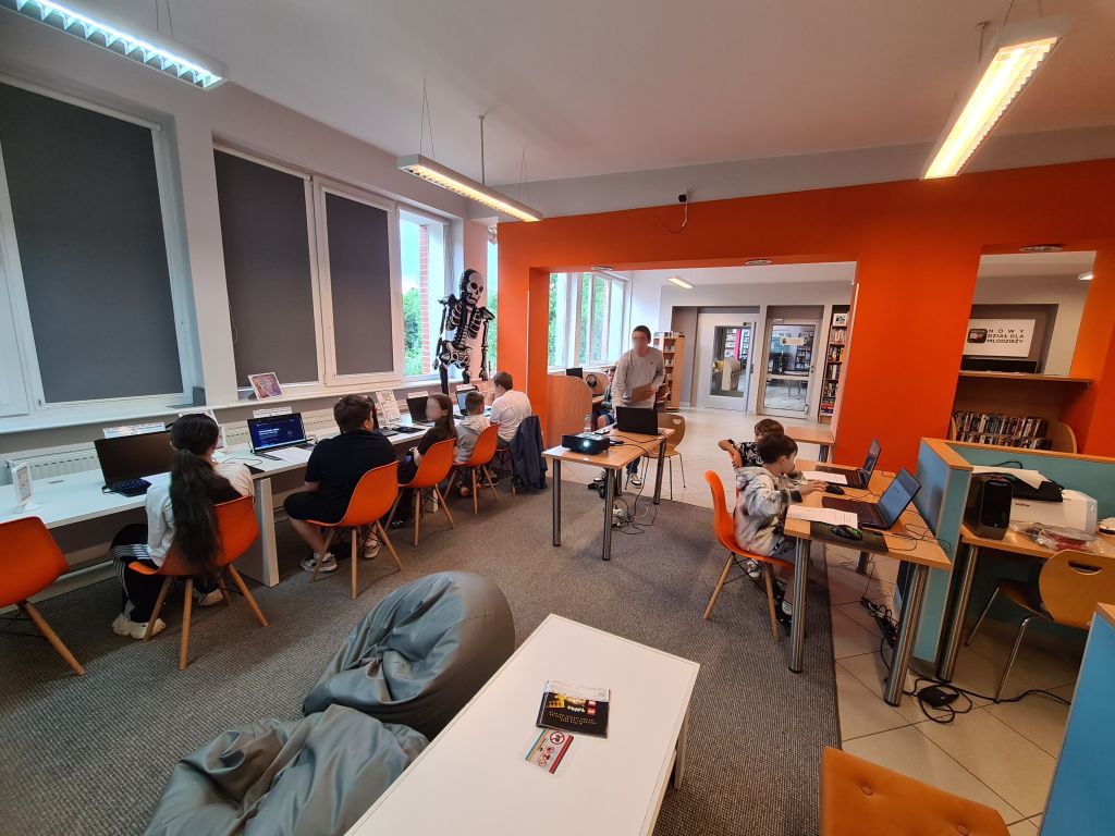 Uczestnicy pierwszego dnia Akademii Nowych Technologii – edycja II podczas warsztatów w Pracowni Orange w Morągu, pracujący przy komputerach nad projektami z wykorzystaniem sztucznej inteligencji i technologii 3D.