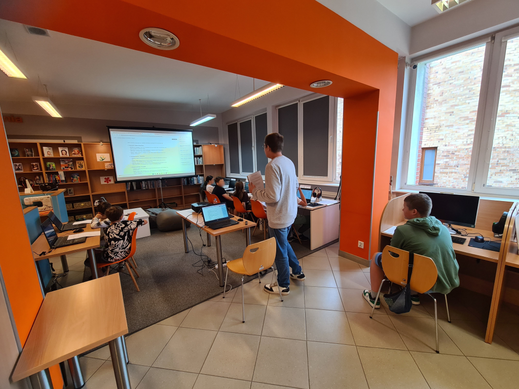 Uczestnicy pierwszego dnia Akademii Nowych Technologii – edycja II podczas warsztatów w Pracowni Orange w Morągu, pracujący przy komputerach nad projektami z wykorzystaniem sztucznej inteligencji i technologii 3D.