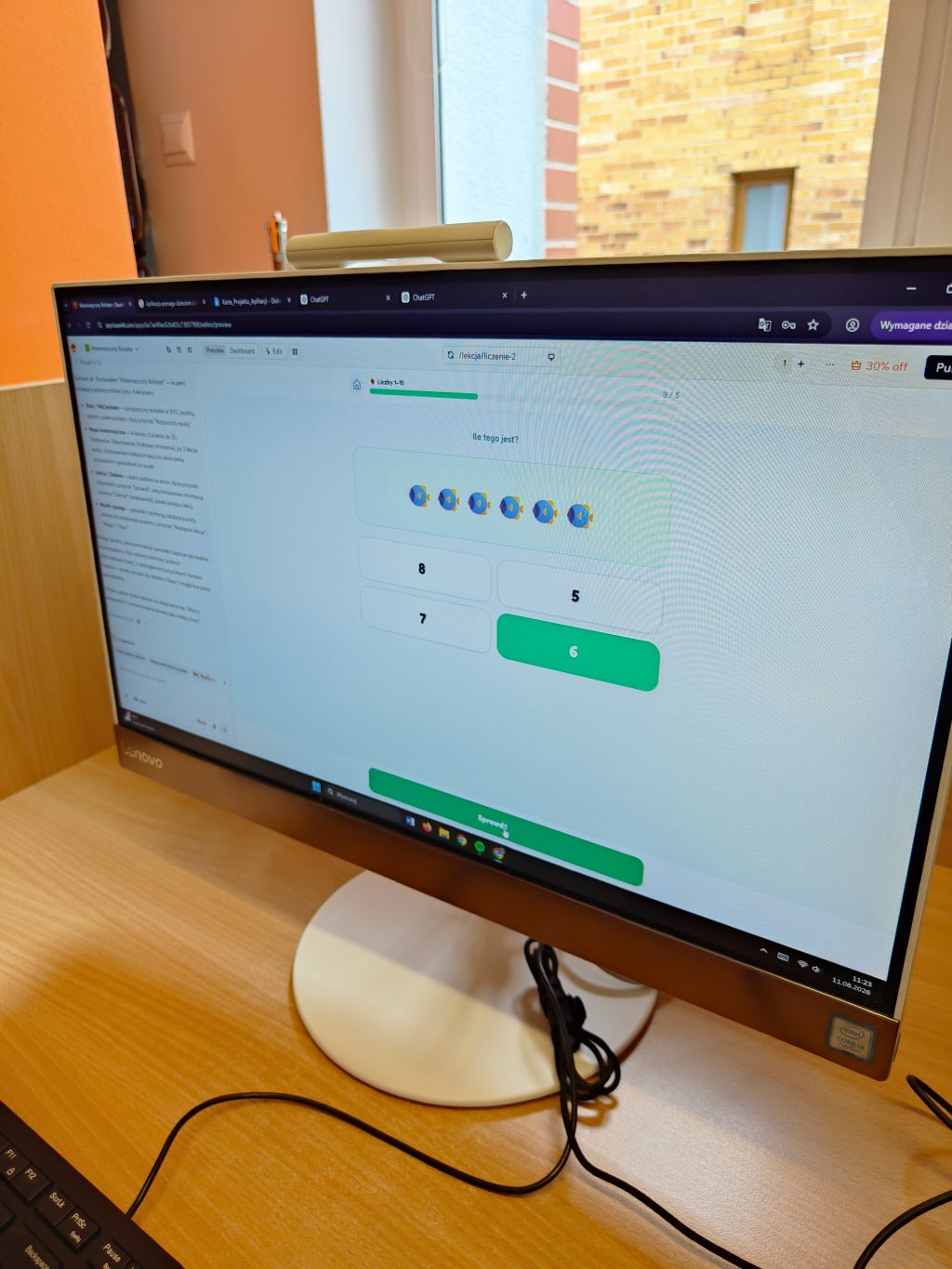 Monitor komputera stacjonarnego Lenovo wyświetlający interaktywne zadanie matematyczne z liczeniem rybek.