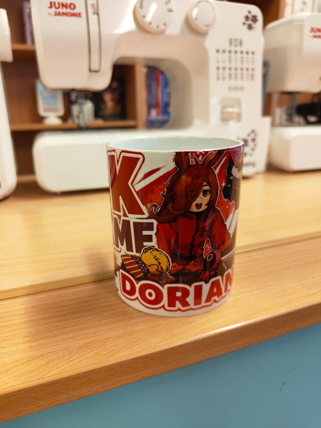 Zbliżenie na ceramiczny kubek z kolorową grafiką z postacią z anime oraz napisem „DORIAN”.