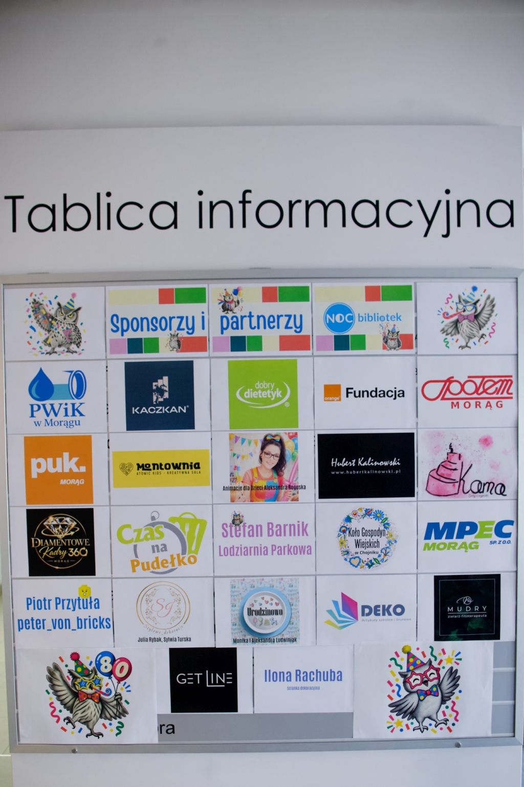 Tablica z logotypami sponsorów i partnerów jubileuszowej Nocy Bibliotek.